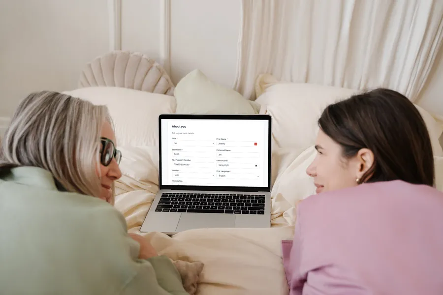 Two people at home completing the GreenNotes patient intake form on a laptop before an appointment