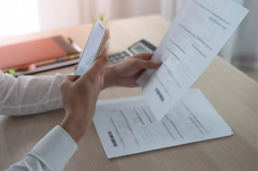A clinician photographing a paper patient form with a phone to capture it into GreenNotes